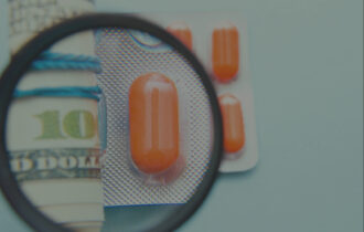 Photo of money rolled up with packaged pills next to the money. There is a magnifying glass over both the money and the pills