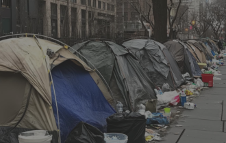 Cluster of tents on the side of a street in a city